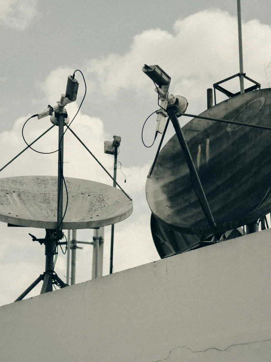 A cluster of parabolic ground-station antennas against cloud.