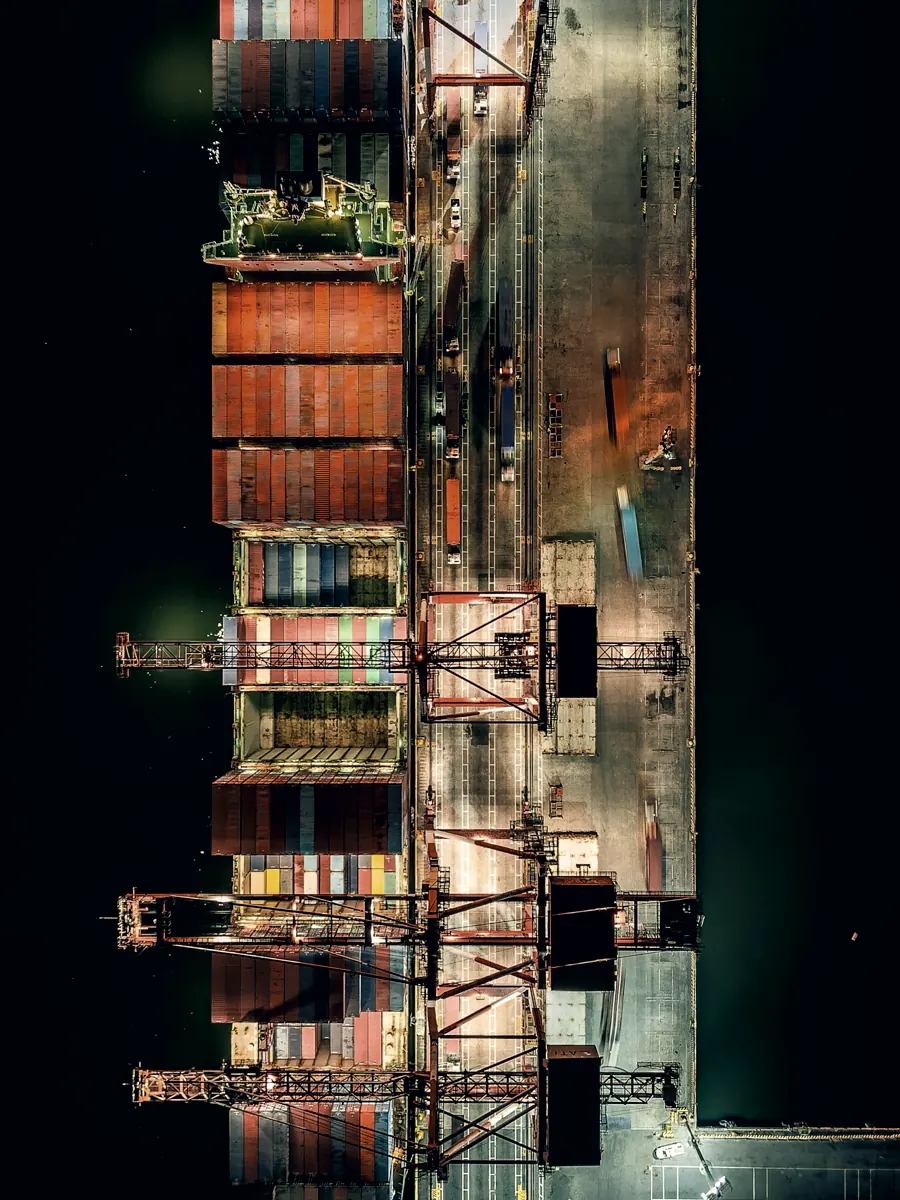 A container vessel alongside a terminal, seen from directly overhead.