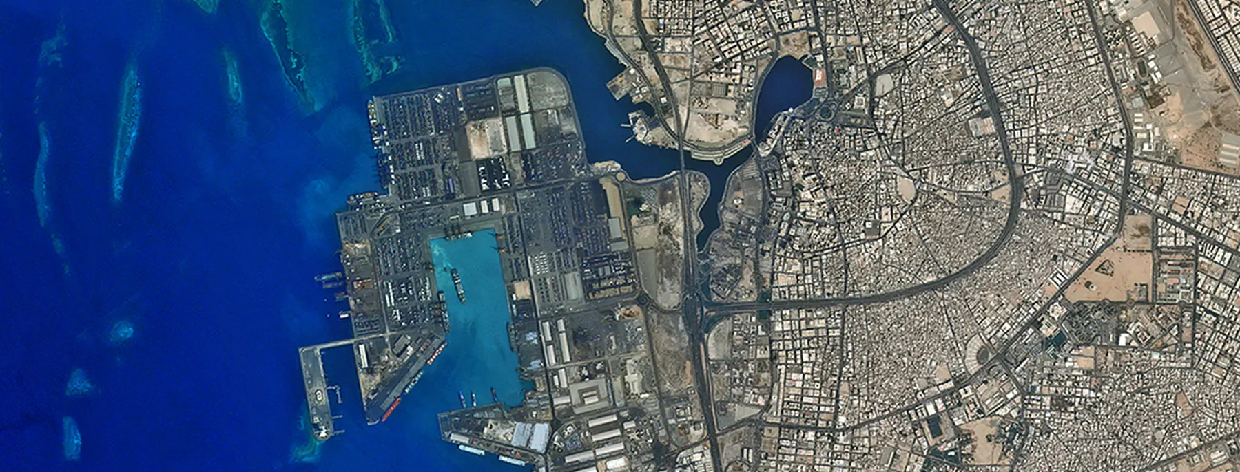 The seaport at Jeddah photographed from orbit, the Red Sea reef shelf visible offshore.
